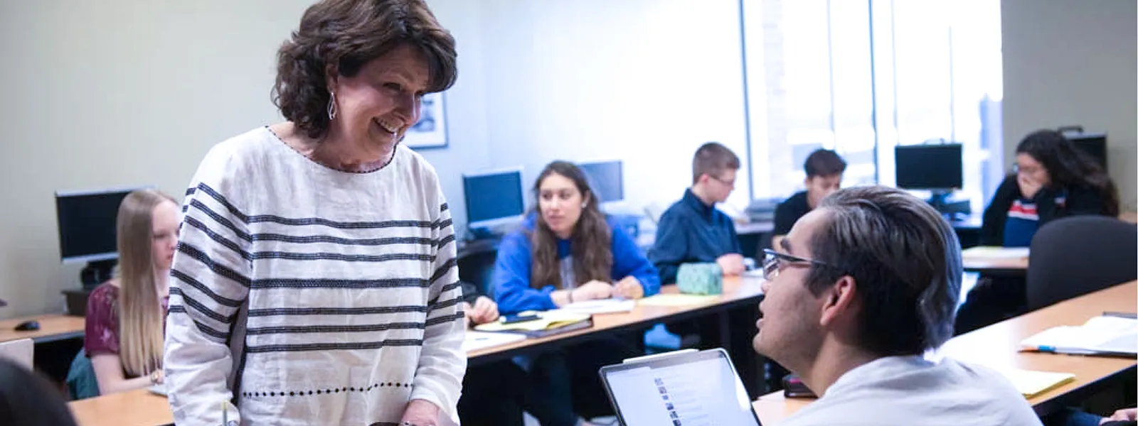 An instructor in a class discussing with a student.