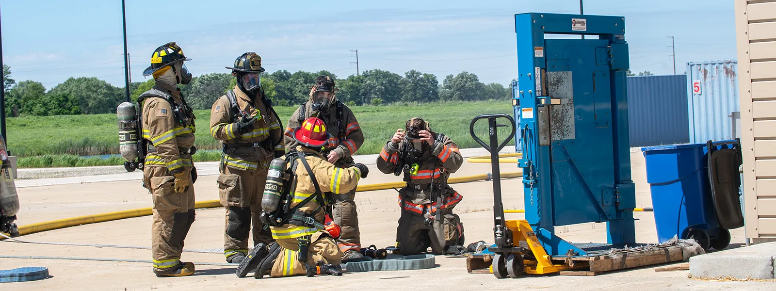 A group of Firefighters training by putting on equipment and ensuring the hose works