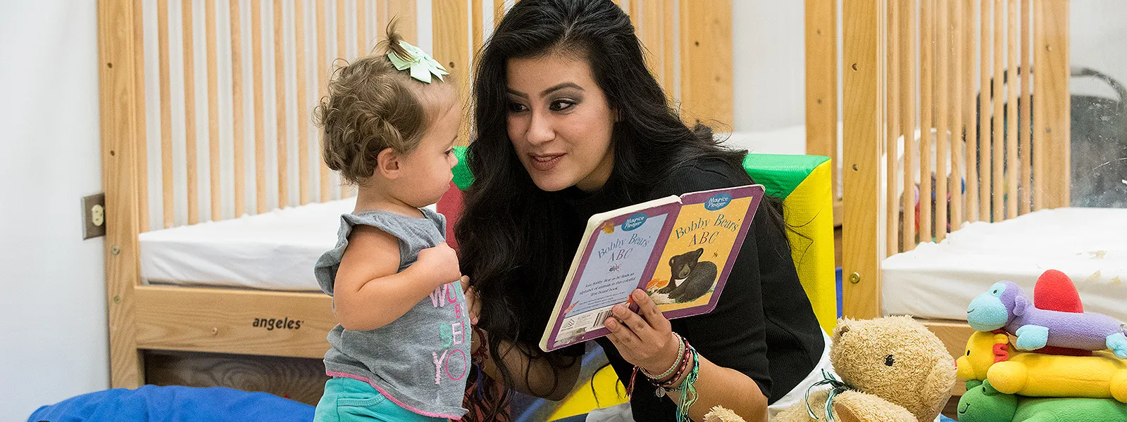 Toddler being read to by ECC staff.
