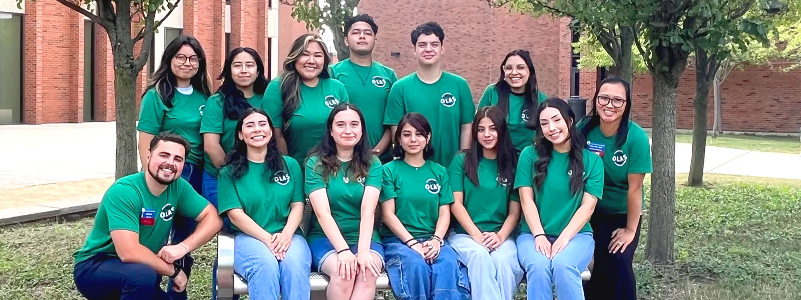11 OLAS students and 2 advisors wearing matching green OLAS t-shirts.