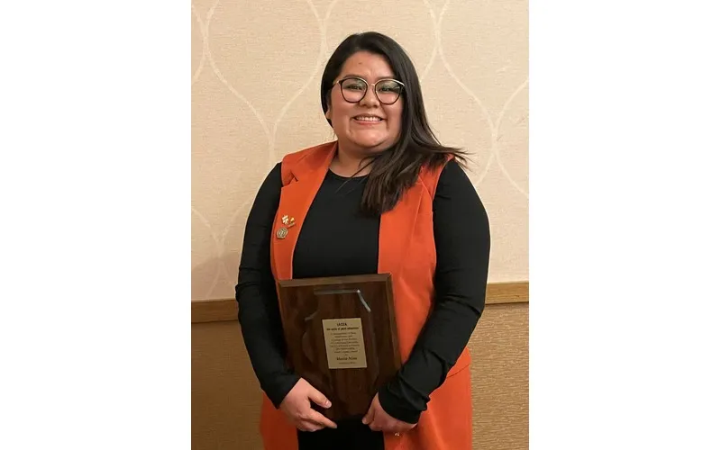 Maria Niño holds her 2026 Paul Simon Adult Learner of the Year Award