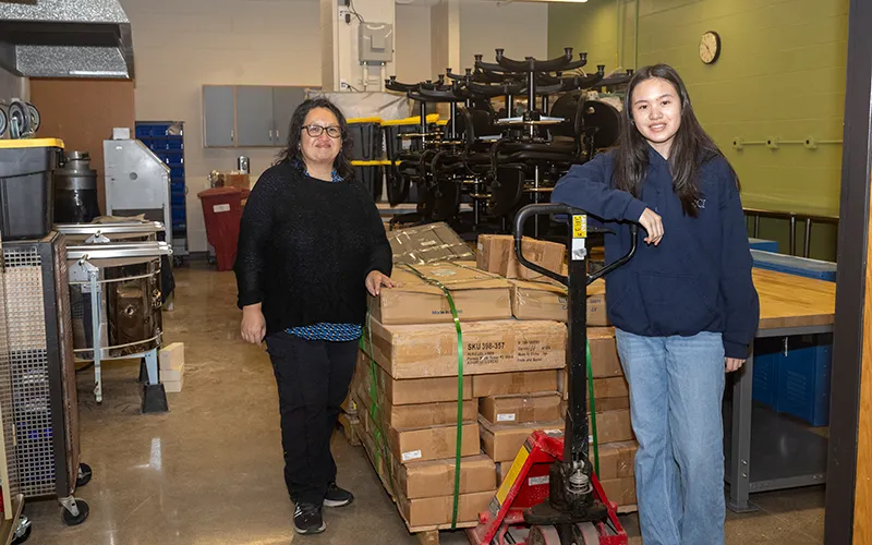 ECC art students Wanchay Itmis and Tiffany Lu stand in a newly renovated room in Building H at Elgin Community College where equipment is being moved back in