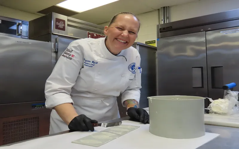 Chef Chrystie Wojcik laughs as she works in the kitchen.