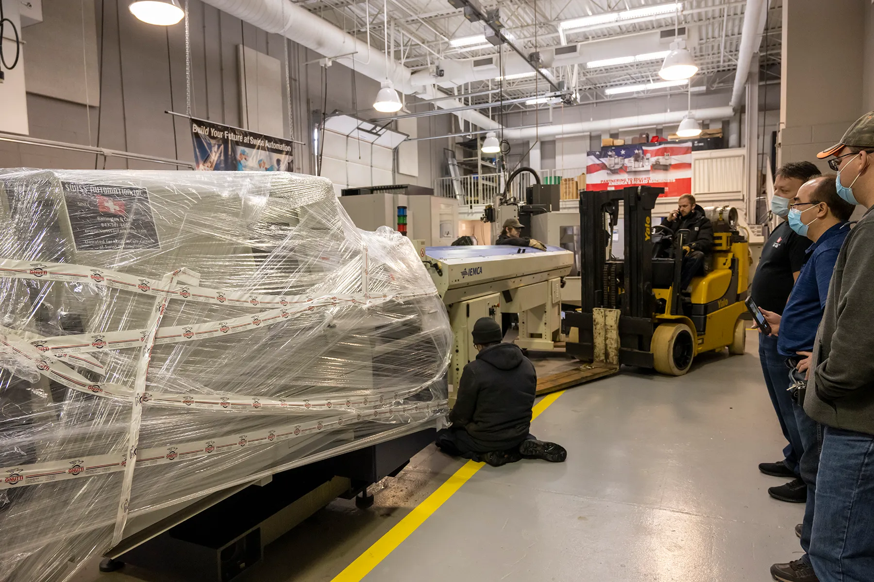 Swiss Automation machine techs install the 9-axis CNC machine in ECC