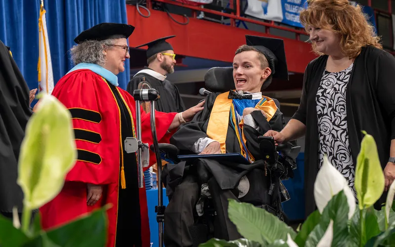 Student receives their diploma at ECC's commencement in May 2025.