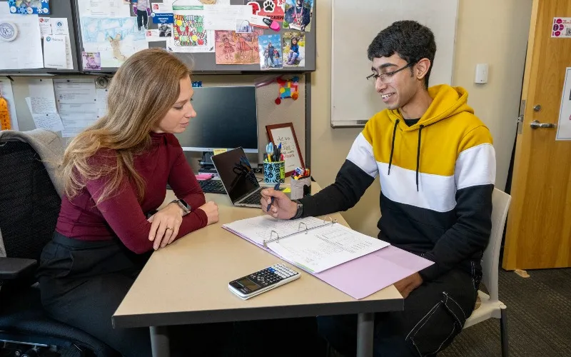Two individuals chat in an office setting.