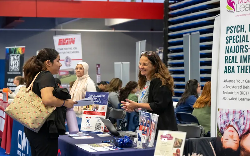 Two people talk at a past ECC Job Fair.
