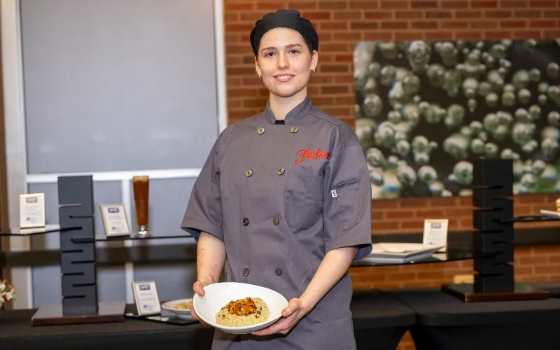 Culinary student Lynn Stringini poses with her Vegan Pistachio Risotto, which won the 2026 Fisher Nuts Recipe Competition.