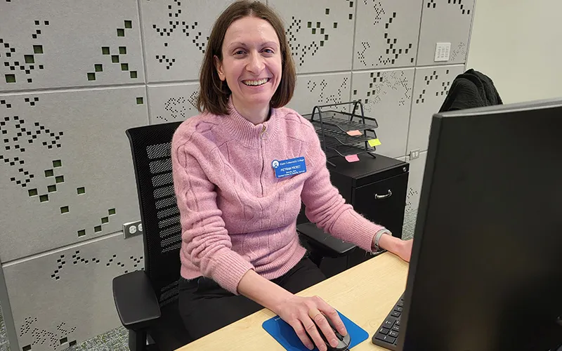 ECC's Director of ADA,Student Access & Disability Services Pietrina Probst sits a desk in the new office for Student Access and Disability Services in Building F, Room 120.