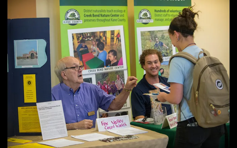 Three people talk during a past volunteer fair at Elgin Community College.