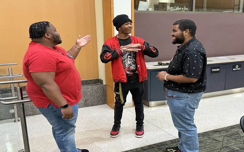 ECC Internship Coordinator Ron Jones talks to two students during Black History Month 2025 celebrations.