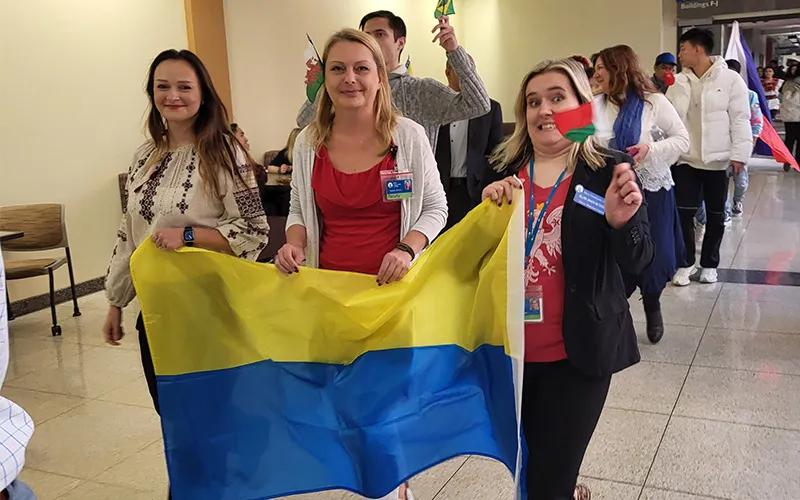 Students walk the hall with international flags during International Week in 2023.