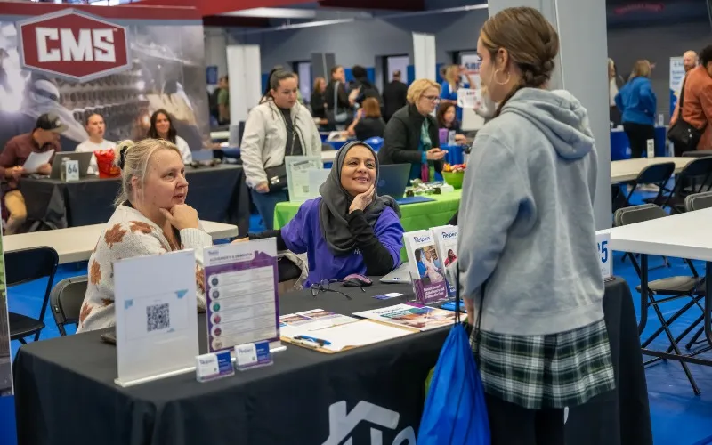 A photo of three individuals mid conversation at the ECC Fall Job Fair in 2025.