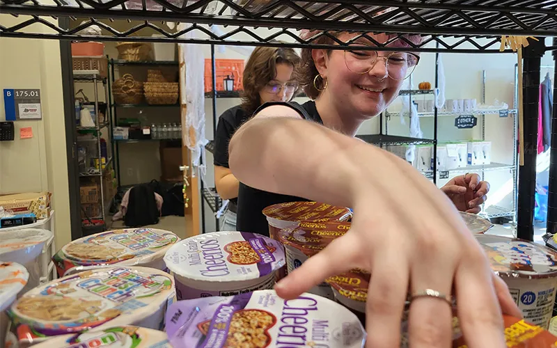 ECC student Laci VerCande restocks the shelves at Spartan Pantry.