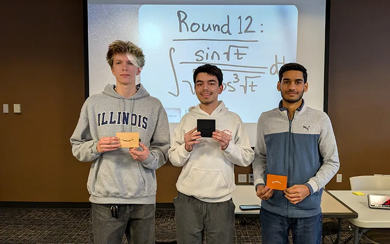 The three winners of ECC's math integration contest in December 2025 pose with their Amazon gift cards.
