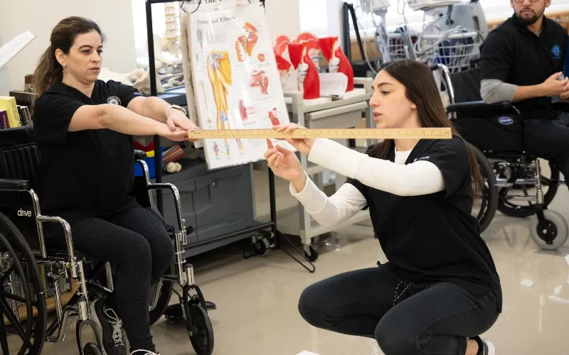 Two individuals take part in a physical therapy class at ECC.
