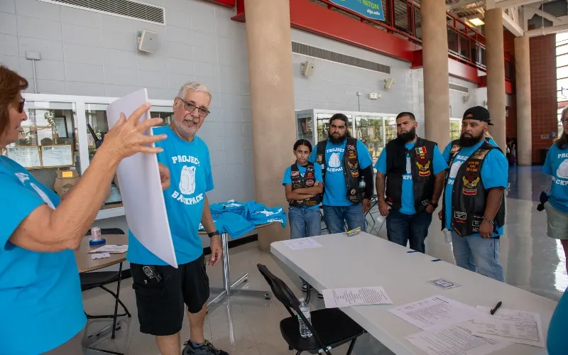 A group of volunteers talk at a past Project Backpack event at ECC.