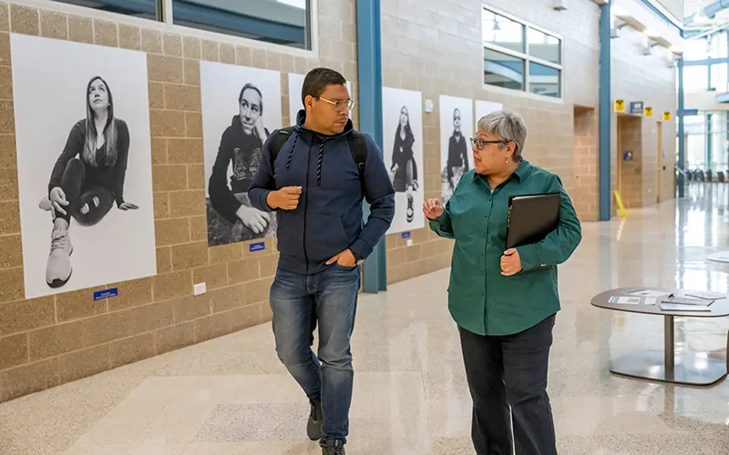 ECC student McGregory Gamez walks with an ECC instructor