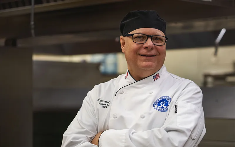 ECC Culinary Arts Alum Raymond Petty poses in a kitchen.