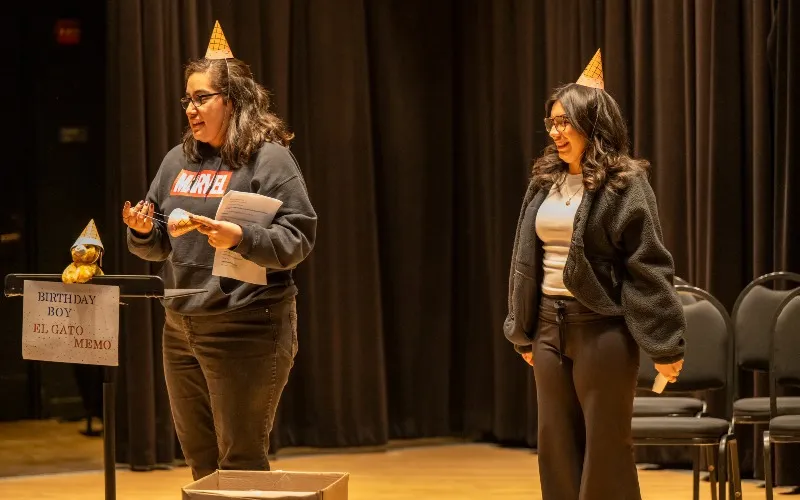 Two ECC students perform on stage for second grade students.