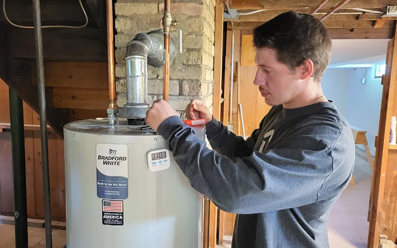 Austin Marmolejo, participante del programa de capacitación para recién llegados sobre eficiencia energética de ComEd/ECC, realiza pruebas de separación de aire simulando una vivienda durante la clase.