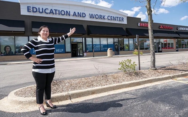 State of Illinois High School Diploma graduate Crisanta Mora stands in front of the Education Work Center (EWC)