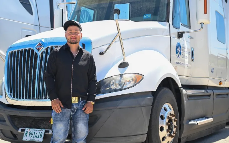 ECC Truck Driving Alum Giovanni Leyva poses next to an ECC vehicle.