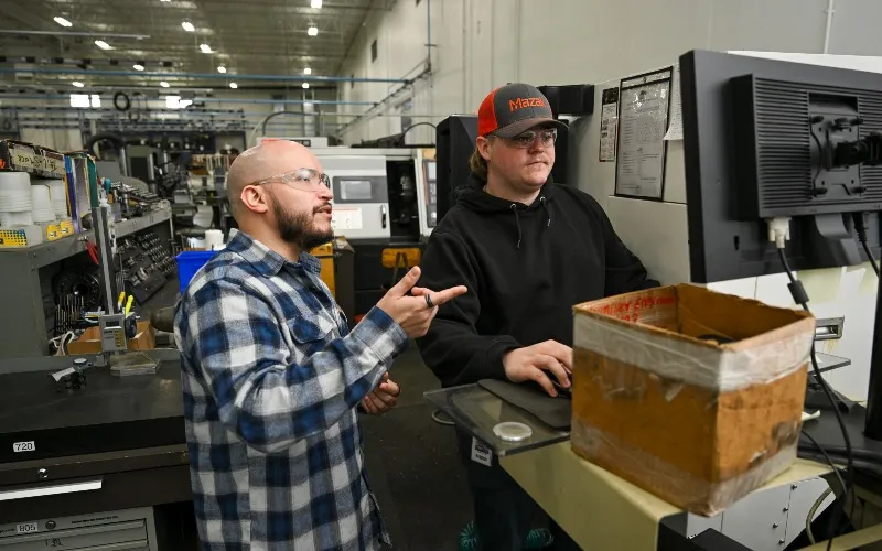 Ivan Colon coaches ECC apprenticeship program students Henry Piehl at Haumiller Engineering in South Elgin.