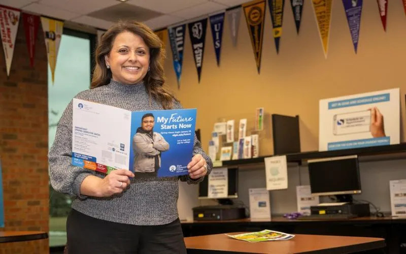 Maggie Im, academic advisor, holds a copy of a registration brochure in the student succes center
