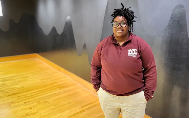 ECC student Maya Wade stand in front of her Wall Art in the Safety-Kleen Gallery