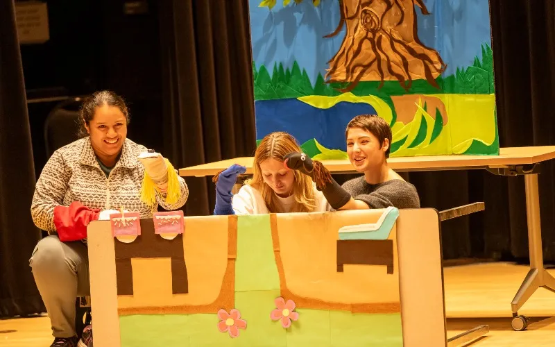 A group of ECC Communication students performs with sock puppets for local second grade students.