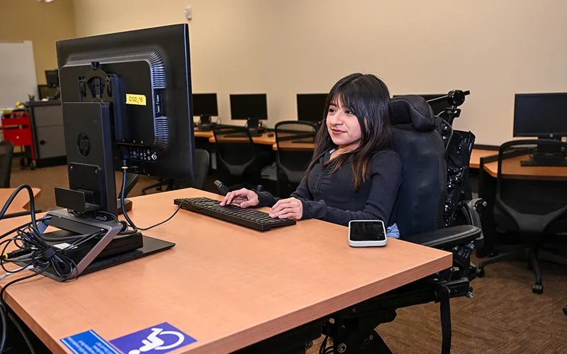 Student in wheelchair uses a computer.