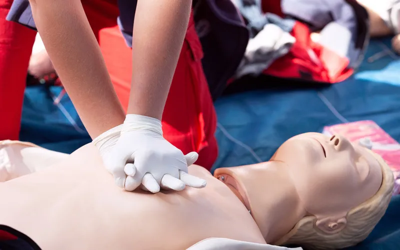 mujer practicando RCP a un maniquí