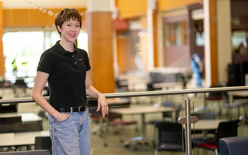 A student stands in the Jobe Lounge