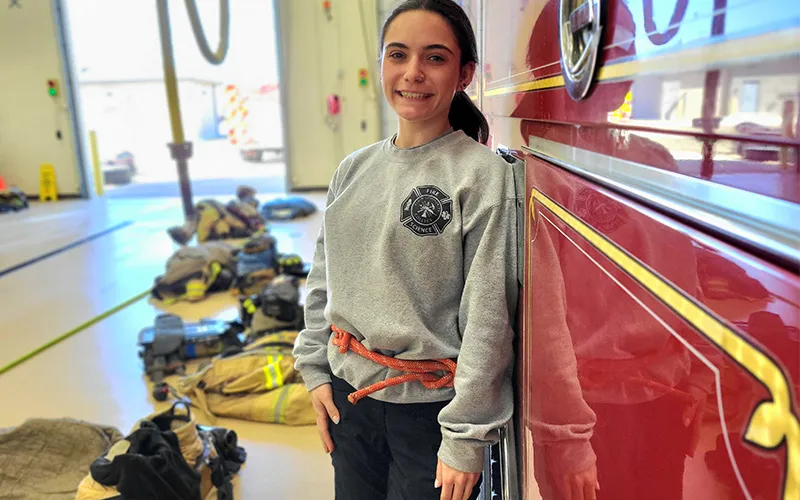 Un estudiante junto a un camión de bomberos