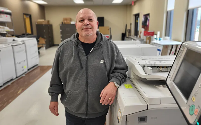 Efrain Matias stands in the ECC Print Shop