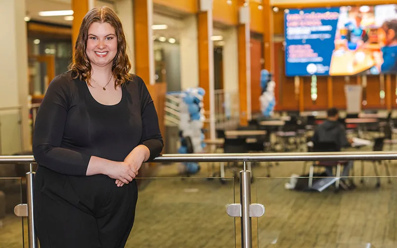 A student stands in the Jobe Lounge