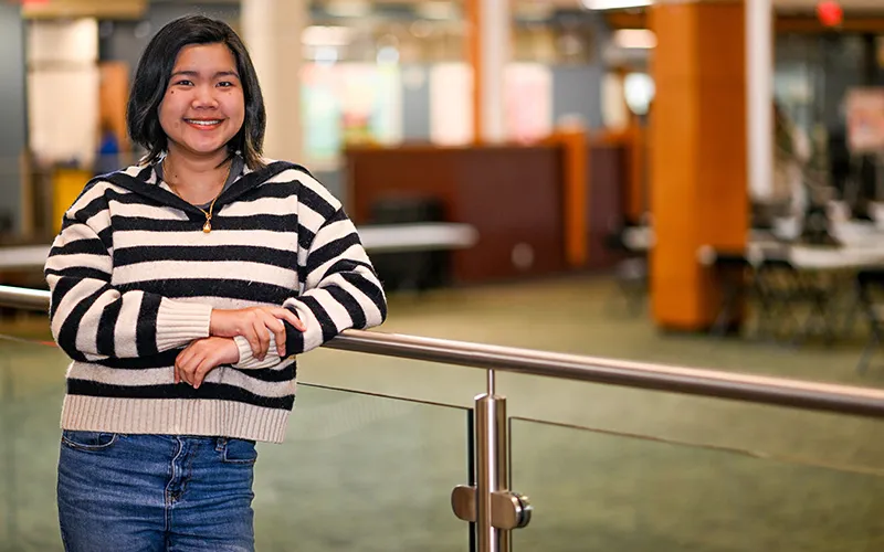 A student stands in the Jobe Lounge