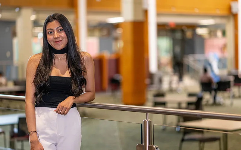 A student stands in the Jobe Lounge