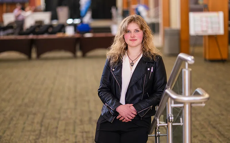 A student stands in the Jobe Lounge