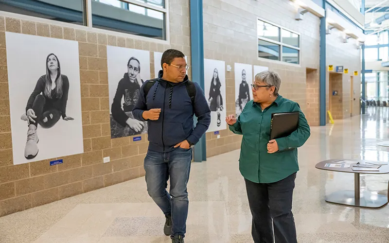 A student and professor walk in the hallway of Building K