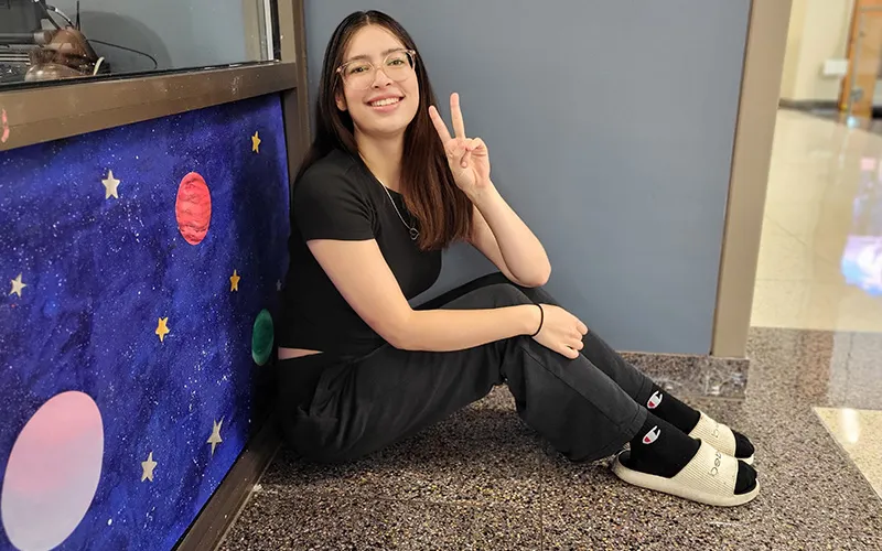 Un alumno se sienta en el suelo