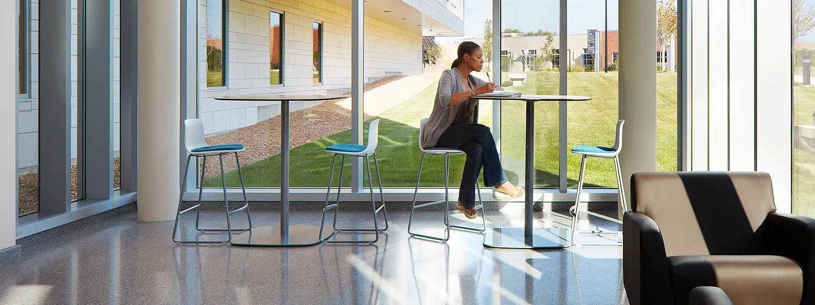 Student sitting at a table reading in Building A.