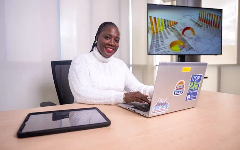 Una mujer sentada en el escritorio sonriendo a la cámara