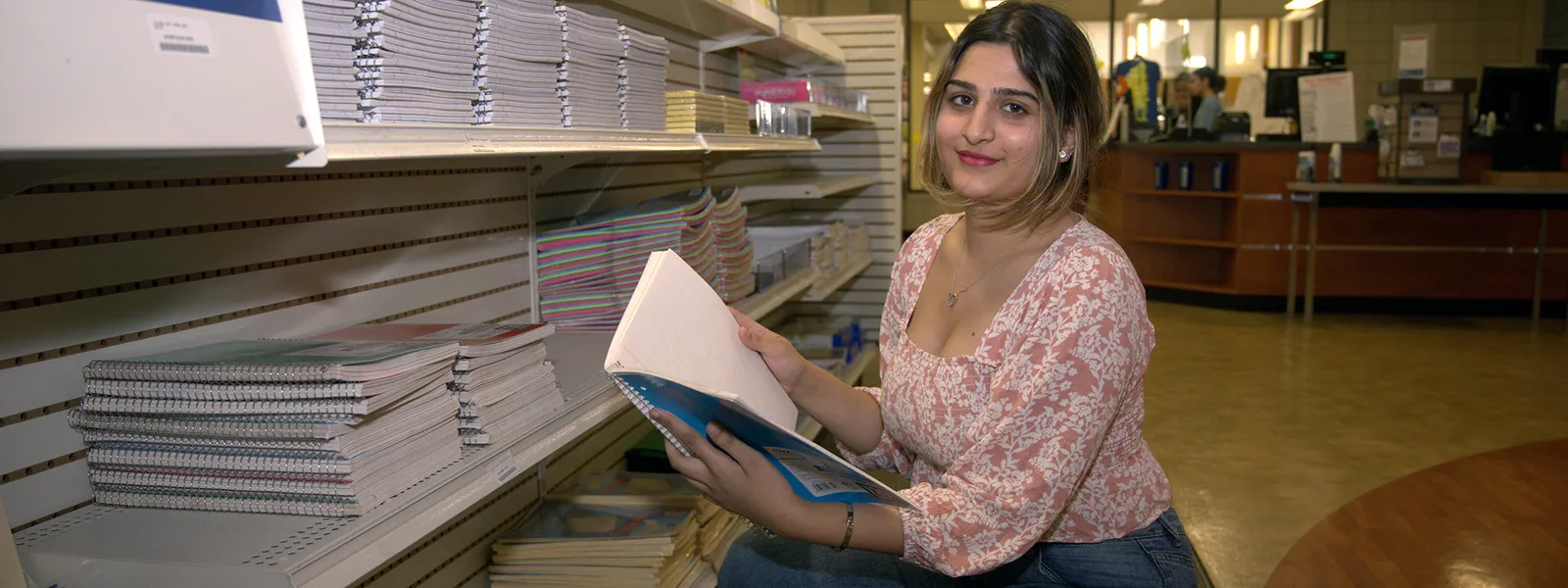 Student looking at a book at the ECC Bookstore