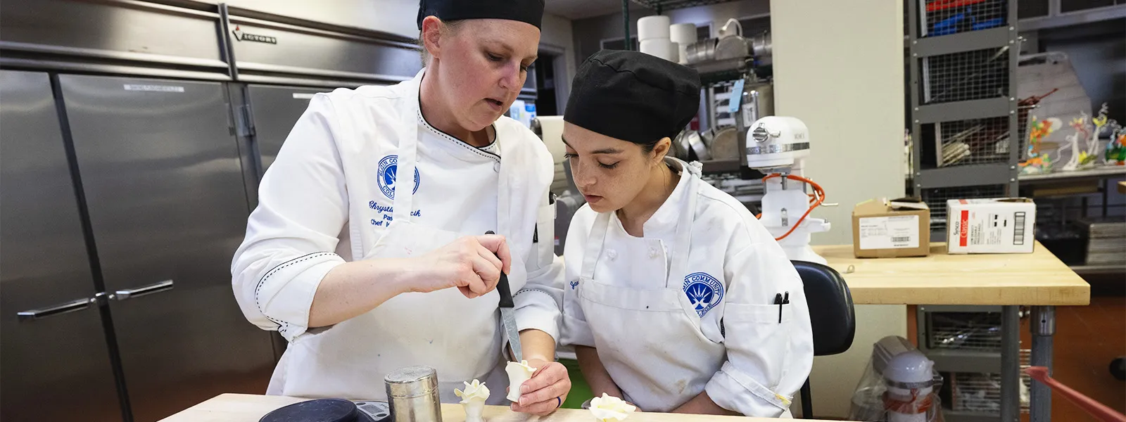 Pastry arts student working with instructor.