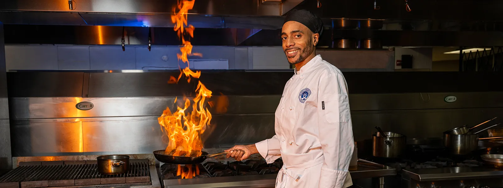 A culinary arts student cooking with fire