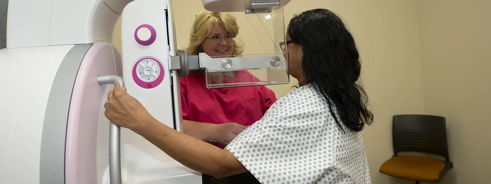 two people using a mammography machine