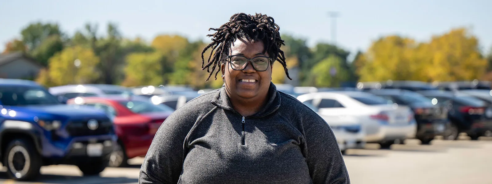Student in outside at ECC in the parking lot waiting for a ride.