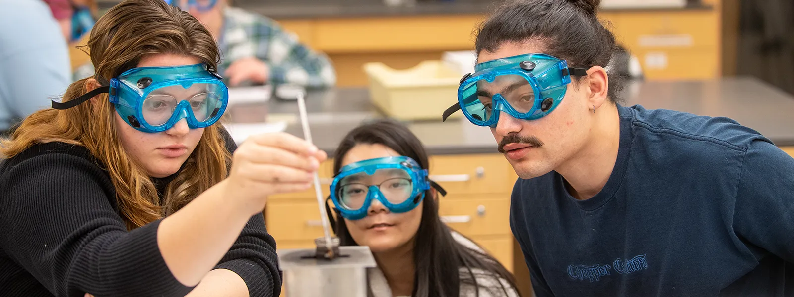 3 ECC science students in lab working together